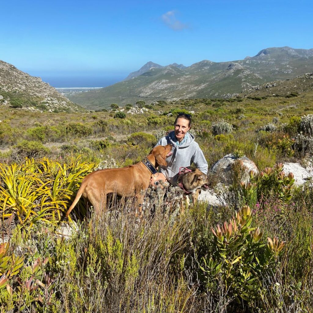 Nala Health team member outdoors in the South African fynbos with two dogs